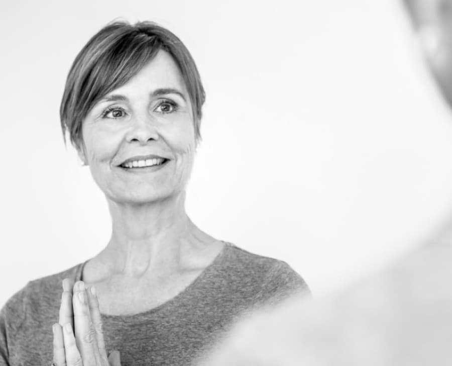 Teilnehmerin mit den Händen in Namaste-Haltung